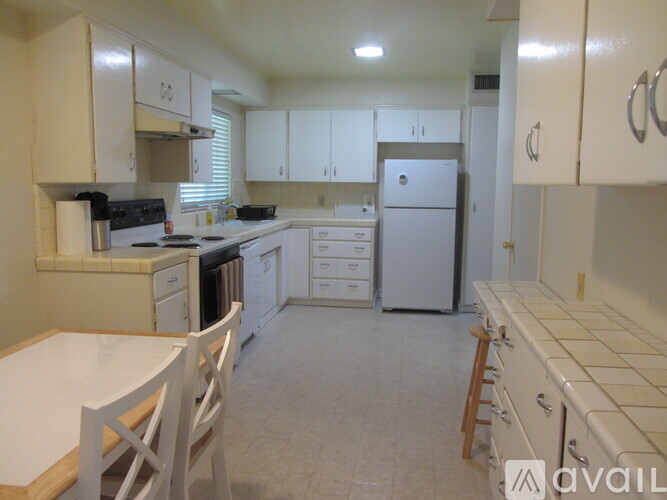 A kitchen with white cabinets and appliances.