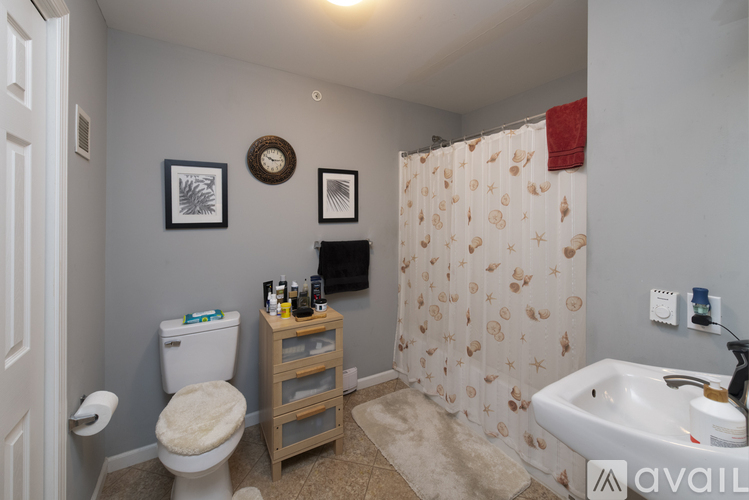 A bathroom with a toilet, sink, and shower curtain.