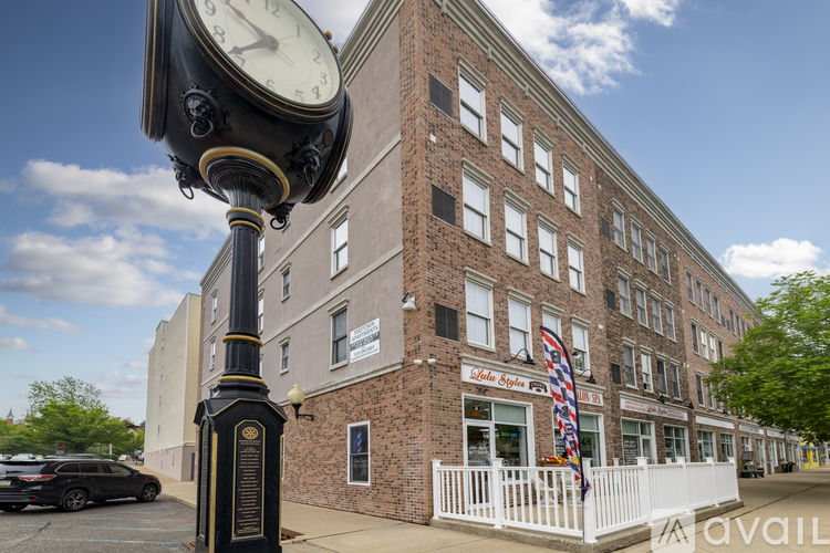 A street scene with a clock tower and a building with a sign that says "Little Clyde's".