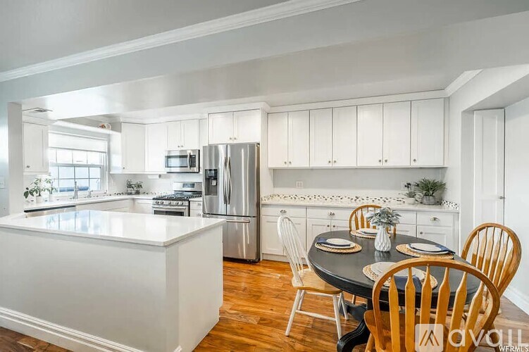 A kitchen with white cabinets and a black table.