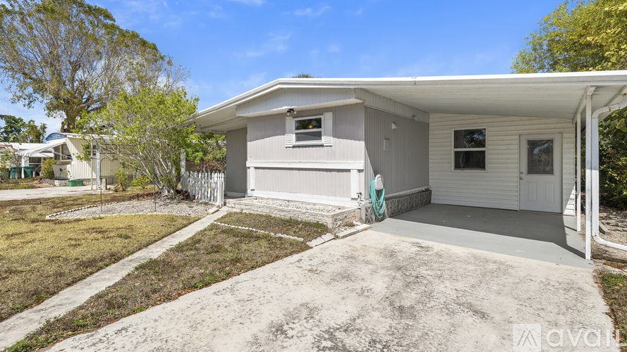 A house with a white exterior and a green hose on the side.