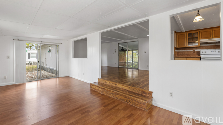 A spacious room with wooden floors and white walls.