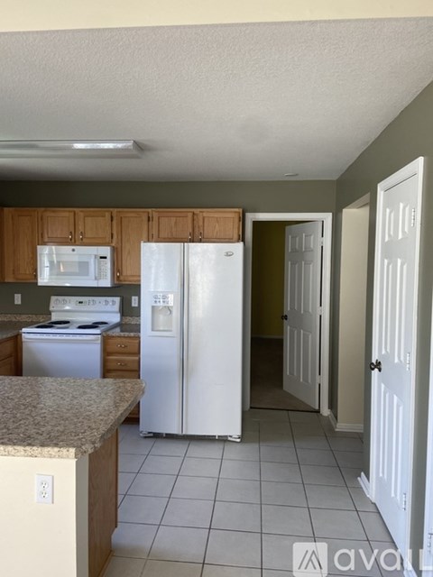 A kitchen with a white refrigerator and microwave.