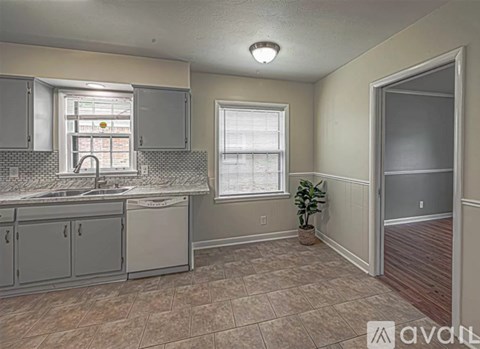 A kitchen with a sink, cabinets, and a window.