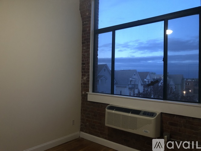 A room with a window overlooking a residential area.