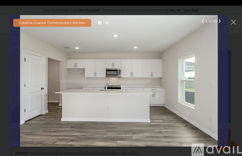 A modern kitchen with white cabinets and a central island.