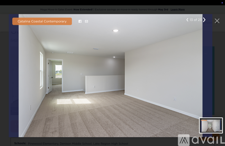 A spacious room with a carpeted floor and white walls.