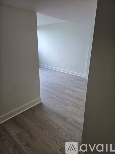 A room with wooden flooring and white walls.