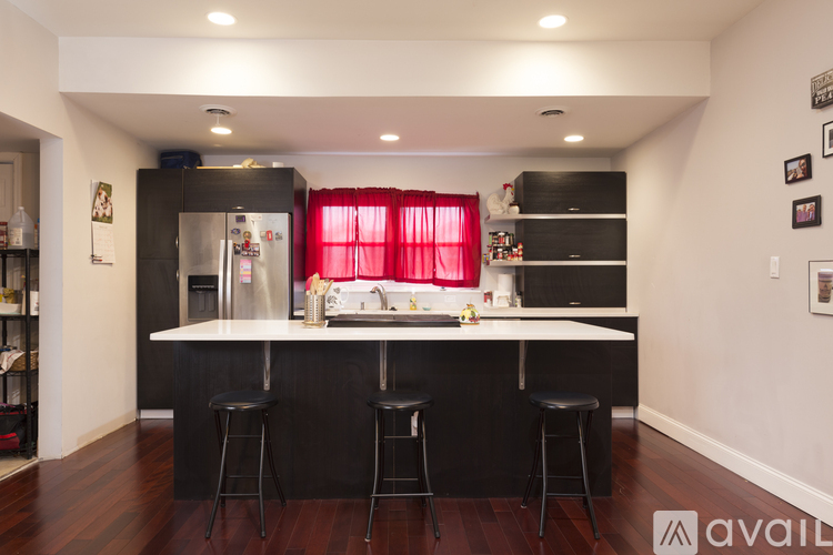 A kitchen with black countertops and stools.