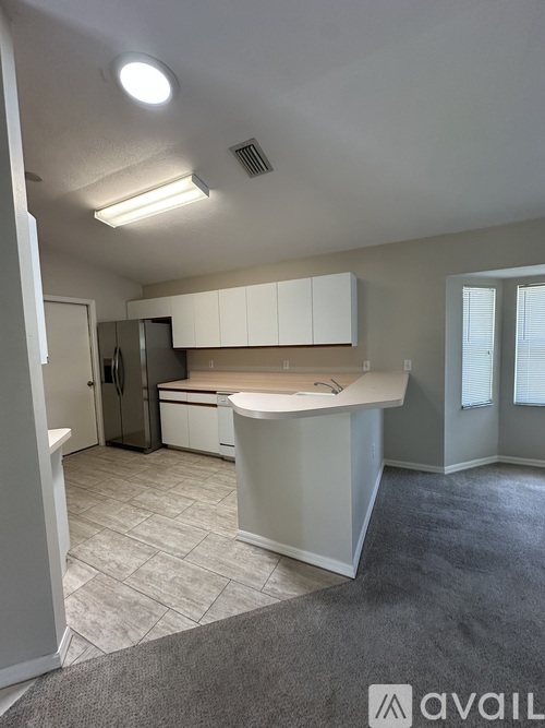 A kitchen with white cabinets and a countertop is shown.