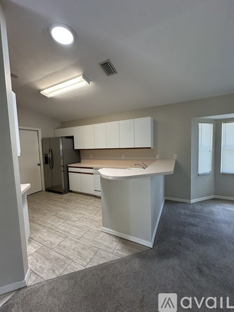 A kitchen with white cabinets and a countertop is shown.