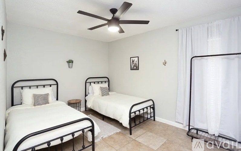 A bedroom with two beds and a ceiling fan.