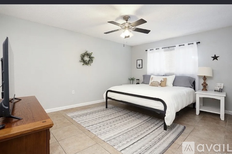 A bedroom with a bed, a small table, and a television.