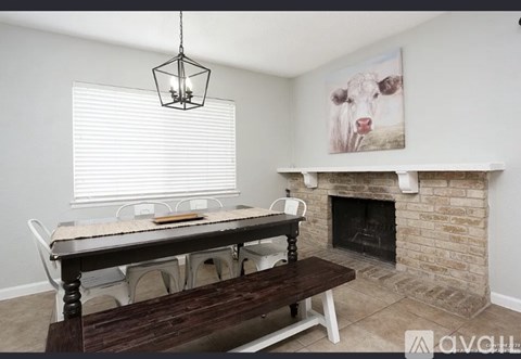 A living room with a fireplace and a painting of a cow on the wall.