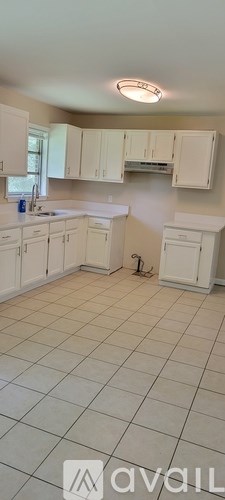 A kitchen with white cabinets and a tiled floor.