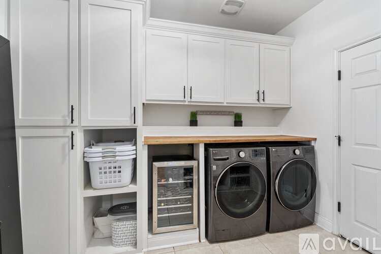 A kitchen with white cabinets and a wooden countertop.