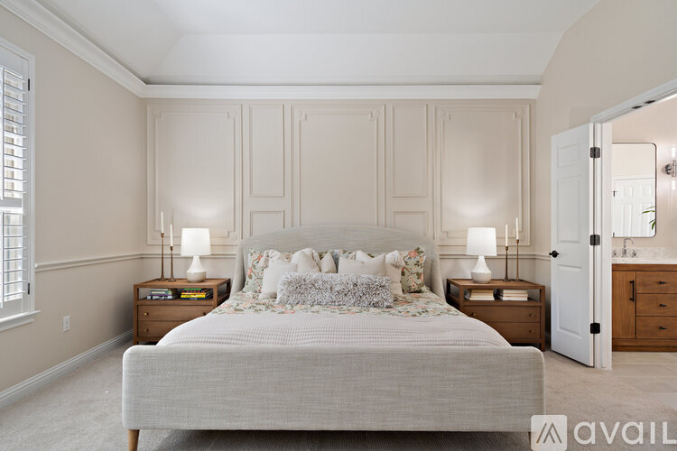 A bedroom with a large bed and two nightstands with lamps.