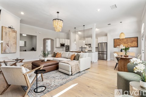 A modern living room with a white sofa set and a wooden coffee table.