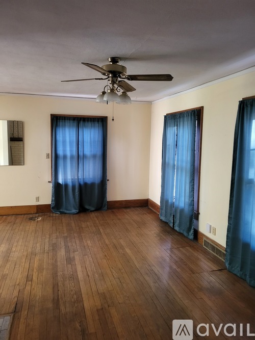 A room with wooden floors and a ceiling fan.