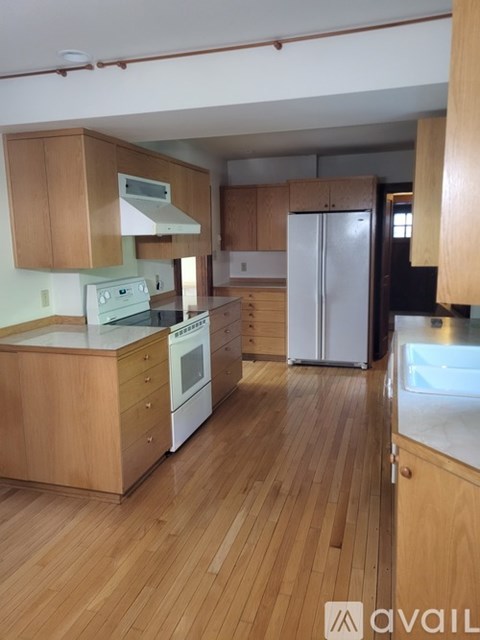 A kitchen with wooden floors and cabinets.