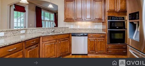 A kitchen with wooden cabinets and a granite countertop.