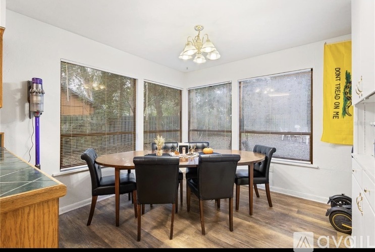 A dining room with a table set for six and a yellow banner on the wall.