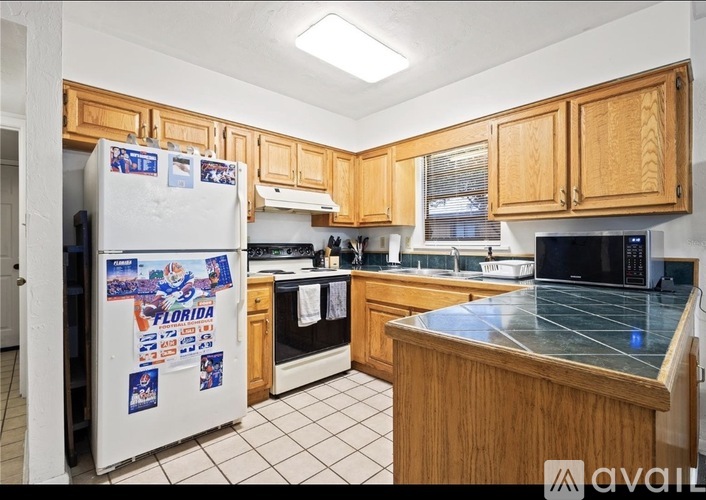 A kitchen with wooden cabinets and a white fridge with a Florida sticker on it.