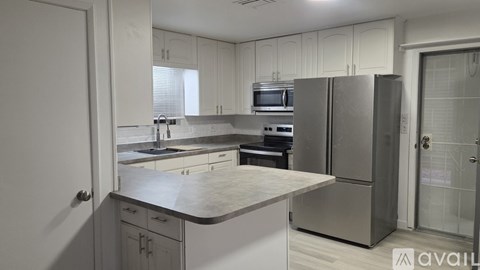 A kitchen with white cabinets and stainless steel appliances.