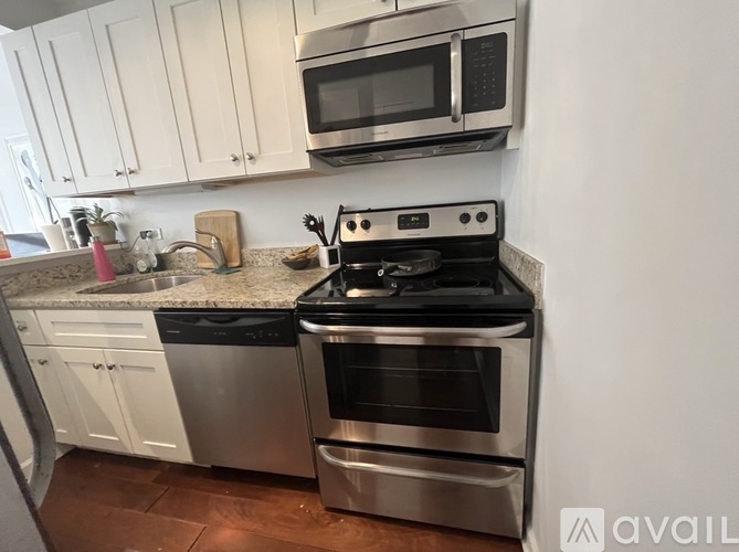 A modern kitchen with a stainless steel oven and microwave above it.