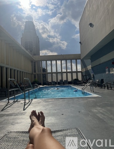 A person is relaxing by a pool with their feet up.