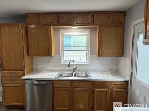 A kitchen with wooden cabinets and a stainless steel sink.