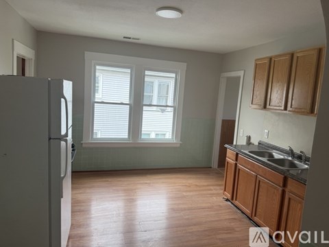 A kitchen with wooden cabinets and a refrigerator.