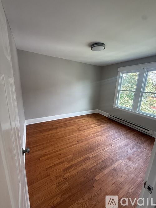 A room with wooden flooring and a window.