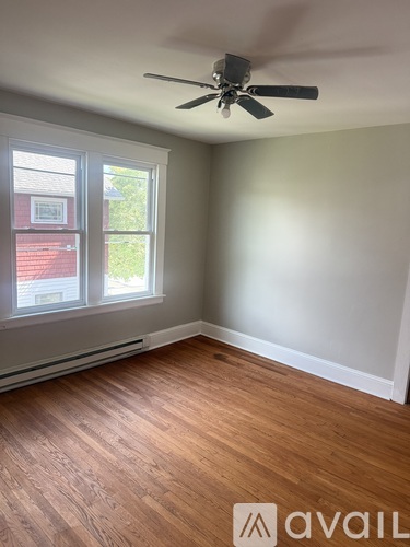 A room with a ceiling fan and a window.