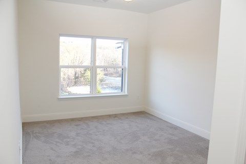 A room with a window overlooking a road.