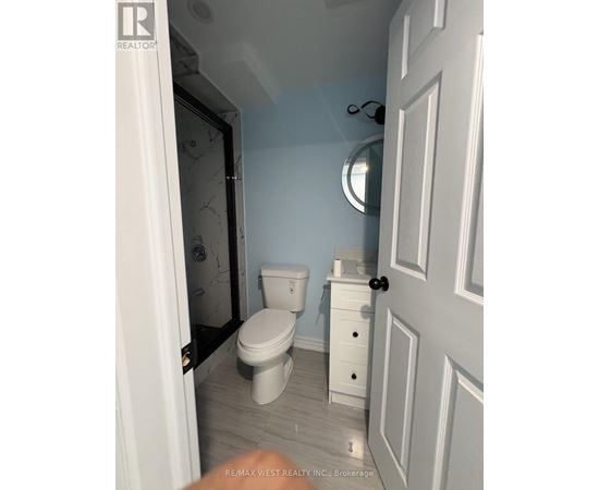 A white toilet and sink in a small bathroom.