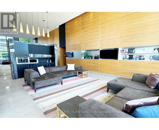 A modern living room with a grey couch and a wooden wall.