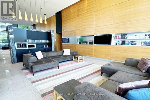 A modern living room with a grey couch and a wooden wall.