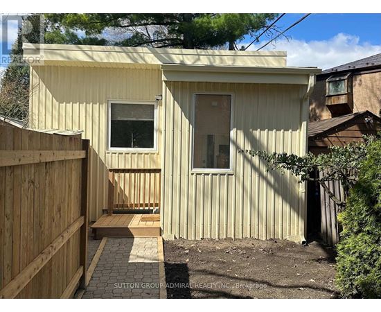 A small house with a wooden fence in front.