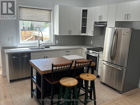A kitchen with a wooden table and stools.