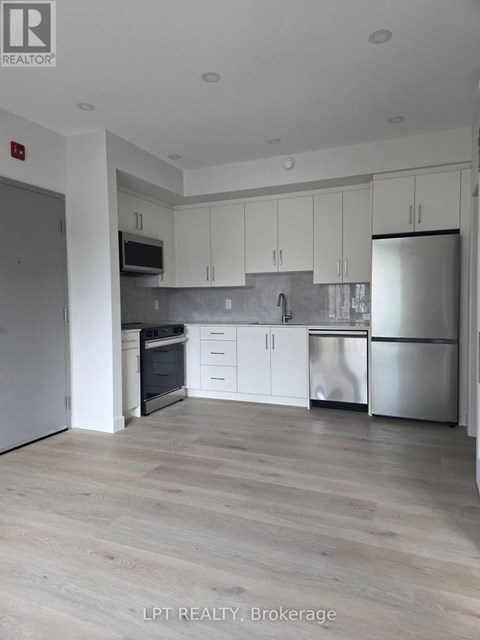 A modern kitchen with white cabinets and stainless steel appliances.