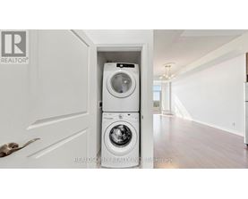 A white washer and dryer are tucked into a small space under a door.