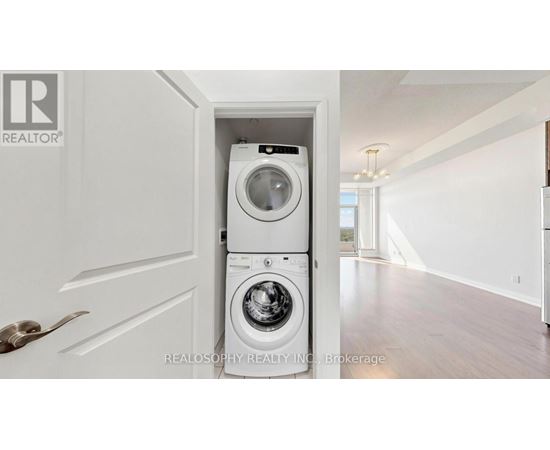 A white washer and dryer are tucked into a small space under a door.