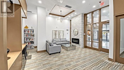 A living room with a grey couch and a fireplace.