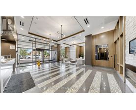 A modern office lobby with a glass wall and a reception desk.