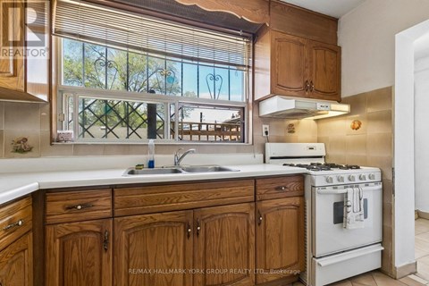 A kitchen with wooden cabinets and a white stove.