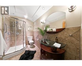 A bathroom with a glass shower stall and a sink.