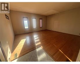 A room with wooden flooring and white walls.