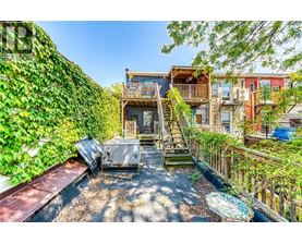 A patio with a hot tub surrounded by a green wall.