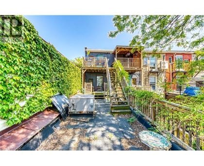 A patio with a hot tub surrounded by a green wall.